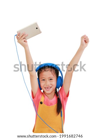 Cheerful Asian little girl child raise hands up enjoy with smartphone and headphones isolated on white background. Image with Clipping path