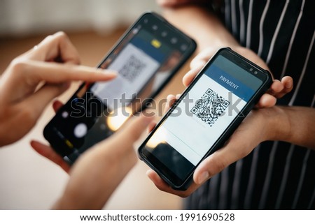 Closeup of a hand holding phone and scanning qr code. QR code payment and cash technology concept. Royalty-Free Stock Photo #1991690528