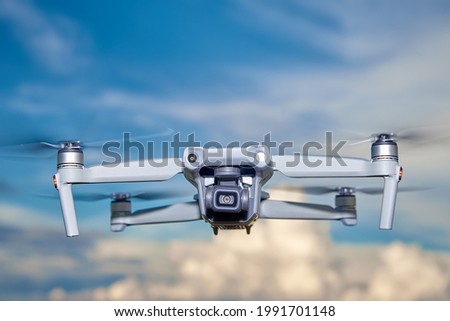 Modern drone with camera in the sky. Flying quadcopter
