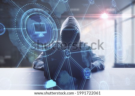 Hacker at desktop using laptop with abstract glowing digital business interface on blurry office background. Hacking and technology concept. Double exposure