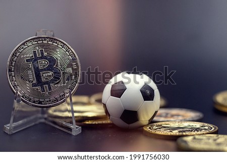 Bitcoin with soccer ball are on black background