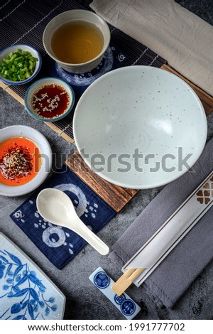 Image of Empty space of dishes or plates conceptual idea Dark brownie plates with the fine ceramic bowls dipping sauce soup and tea ; Japanese style pre-production
