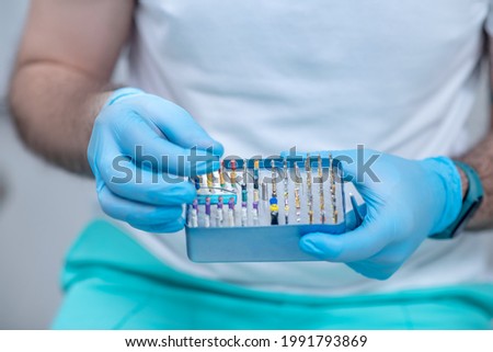 Close up picture of doctors hands with dental medical tools