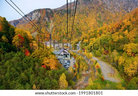 
A breathtaking aerial view from a cable car of Kurodake Ropeway flying over colorful autumn forests on the mountainside of Sounkyo Gorge in Daisetsuzan National Park, in Kamikawa, Hokkaido, Japan Royalty-Free Stock Photo #1991801801