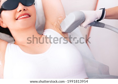 Young girl close-up receiving laser epilation of the armpit. Royalty-Free Stock Photo #1991813954