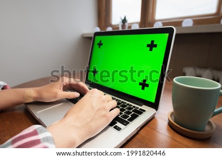 Woman using laptop with green screen. Business, communication, freelance and internet concept. Working at a laptop at home