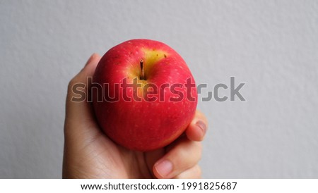 Woman hand holding red app on white background.