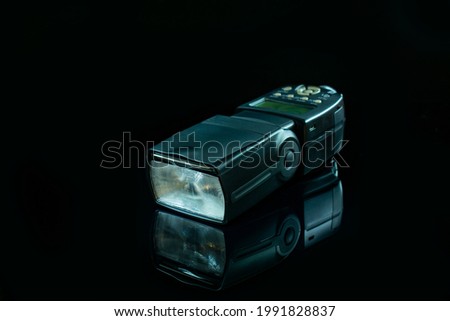 handheld flash on black glossy background 