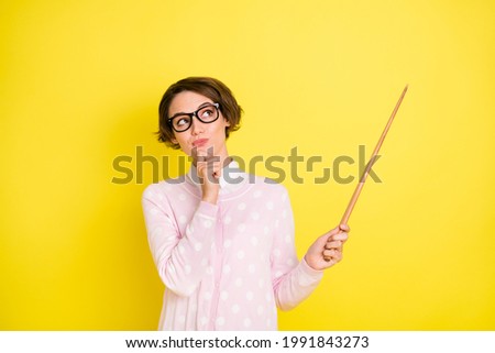 Photo of minded dreamy young woman point stick empty space tutor tracher isolated on vivd yellow color background Royalty-Free Stock Photo #1991843273