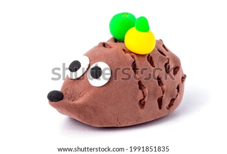 Hedgehog with apples on pins and needles from air plasticine isolated on a white background. Children's creativity
