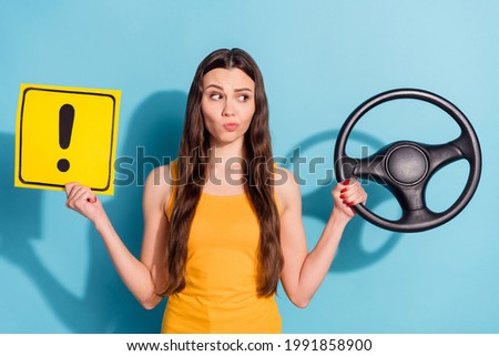 Photo portrait girl unsure keeping steering wheel showing road sign misunderstanding isolated pastel blue color background
