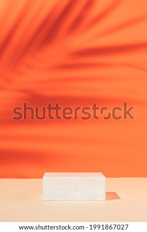 Minimal modern product display on orange background with podium with tropical palm leaf shadow. Suitable for Product Display and Business Concept.