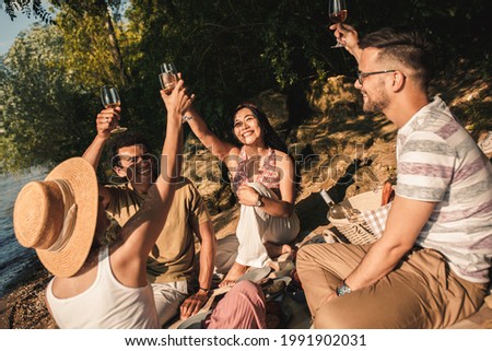 Diverse group of friends enjoying picnic by the river.