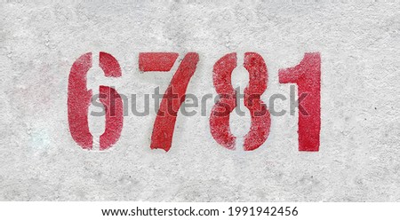 Red Number 6781 on the white wall. Spray paint. Number six thousand seven hundred and eighty.