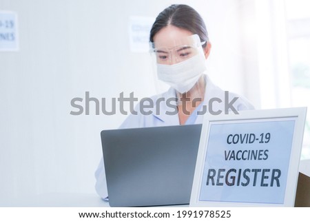 Staff medical woman preparing for register of patient to receive a vaccine at clinic of hospital. Nurse wearing protective mask against covid-19 with a smile on his face.