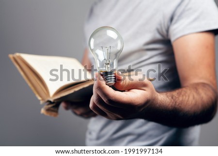 man holding an open book and a light bulb. concept idea from a book