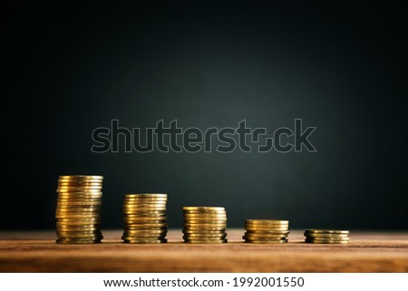growing stack of coins on wooden table. financial success and management concept