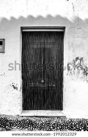 Striped metal curtain on door of village house in Altea, Alicante, Spain