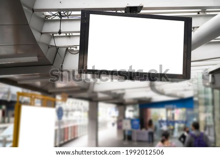 Close up the mock up and blank white screen billboard for advertising or information hanging near to escalator in airport terminal, with clipping path