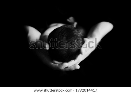 A black-and-white picture of a father holding a cute little baby