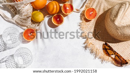Summer fashion banner flat lay on white background. Holiday party, vacation, travel, tropical concept. Straw hat, sunglasses and citrus fruits. Palm shadow and sunlight, sun. Top view, copy space Royalty-Free Stock Photo #1992021158