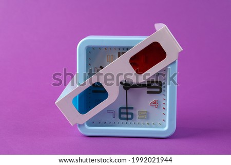 Alarm clock with 3d glasses on purple background