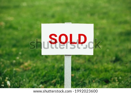 land sold plate sign, green grass background