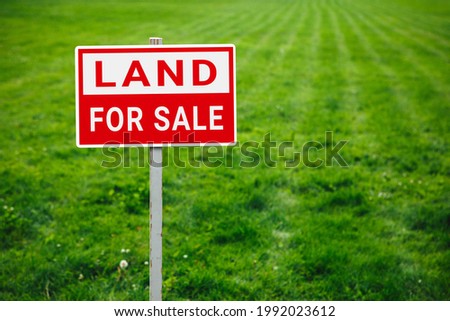 land for sale plate sign, green lawn background