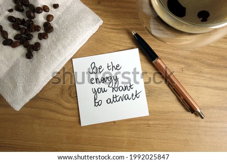 Be the energy you want to attract text handwritten on sticky note with coffee and pen, law of attraction concept Royalty-Free Stock Photo #1992025847