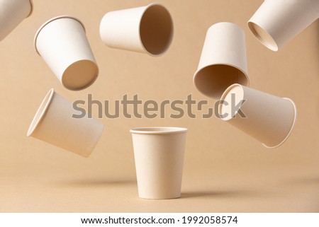 many recyclable cardboard cups floating on a kraft cardboard bottom Royalty-Free Stock Photo #1992058574