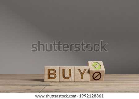 Wood cubes with acronym 'BUY' on a beautiful wooden table, studio background. Business concept with copy space.