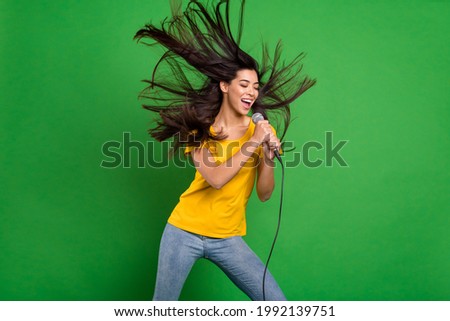 Photo portrait of dreamy girl with long brunette hair singing on festival isolated vibrant green color background