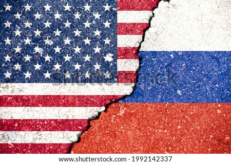National flags of the United States and Russian Federation on the texture of the asphalt surface with a crack between them Royalty-Free Stock Photo #1992142337