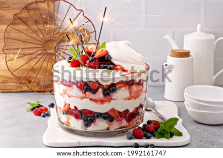 Summer berry red, white and blue trifle with angel food cake in a large bowl. Dessert for 4th of July, Independence day sweet treat with sparklers Royalty-Free Stock Photo #1992161747