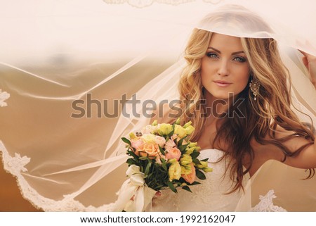 Beautiful blonde bride with bouquet of pink flowers outdoor. Portrait of the bride. Beautiful wedding bouquet Royalty-Free Stock Photo #1992162047