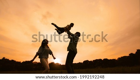 silhouette of asian parent play with kid outdoor