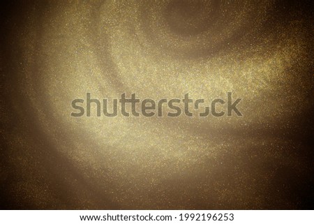 Golden glitter dust on dark background.