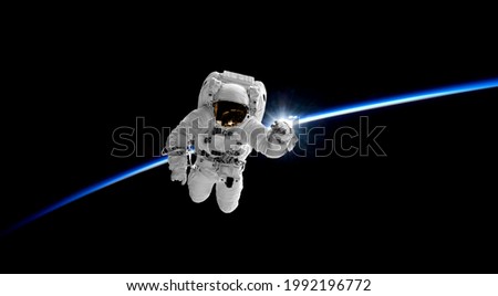 astronaut in outer space  earth and horizon has rising sun. Elements of this image furnished by NASA
