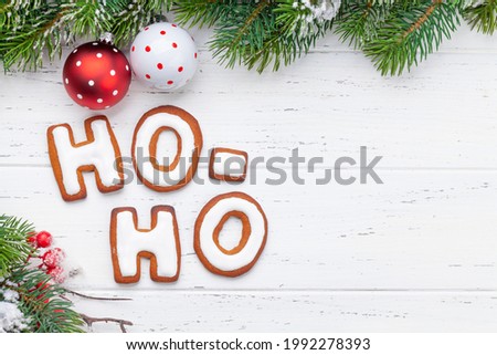 Christmas greeting card with homemade gingerbread HO HO HO text and fir tree. Top view flat lay with copy space