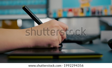 Close up of color designer woman retoucher editing customer photo using computer with two displays and stylus pen. Graphic editor retouching assets drawing on graphic tablet in creative agency