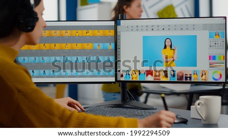 Professional photographer sitting at desk putting on headphones for listening music using PC in photo studio retouches. Content creator doing portrait retouching using post production software