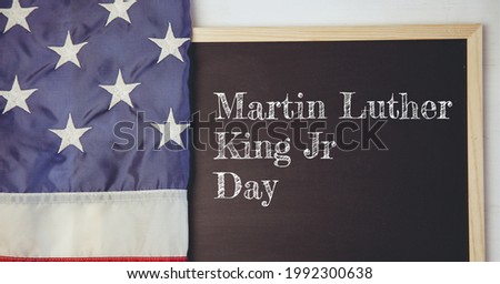 Happy martin luther king jr text on wooden slate and american flag on white background. happy martin luther king jr day template background design concept