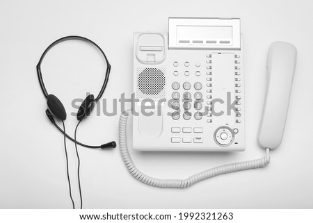 Headset and telephone on white background