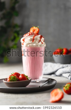 Strawberry milkshake with cream and berries.  Royalty-Free Stock Photo #1992326510