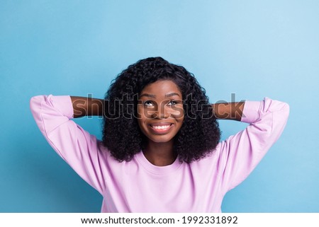 Photo of charming cheerful dark skin lady arms behind head look up empty space isolated on violet color background