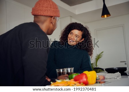 African American couple drinking coffee. Mixed race couple looking at each other in the kitchen at home. High quality photo