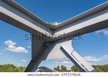 iron steel frame construction of bridge on blue sky background. bridge metal structures, frames, bolts and nuts