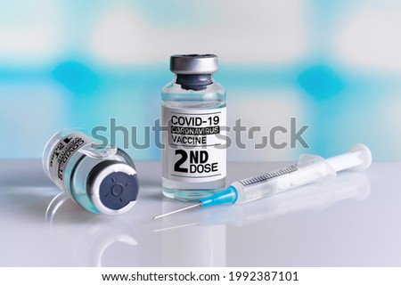 Two COVID-19 Vaccine Vials tagged with 1st and 2nd dose for vaccination of patients. Vaccine bottles identified with first and second dose labels for covid-19 immunization Royalty-Free Stock Photo #1992387101