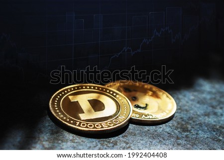 Dogecoin cryptocurrency coins in close-up in the dark against the background of the growth graph Royalty-Free Stock Photo #1992404408