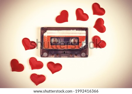 Toned Photo of Old Audio Cassette with a Red Hearts on the Paper Background closeup